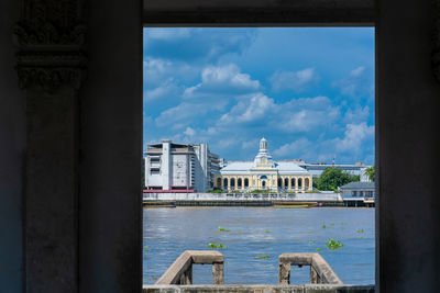 Buildings in city against cloudy sky