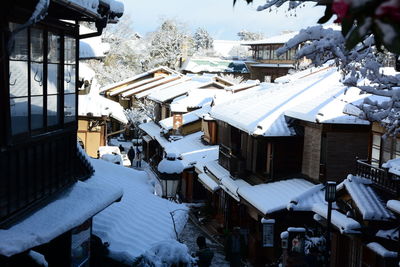 High angle view of snow covered houses and buildings in city