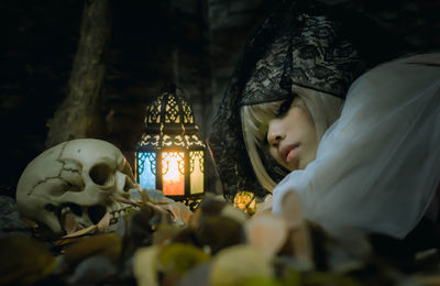 Portrait of woman wearing halloween costume lying on leaves