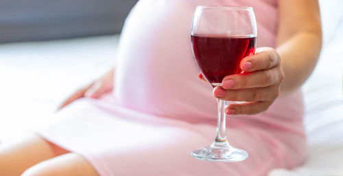 Pregnant woman holding wineglass