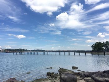 Bridge over river against sky in city