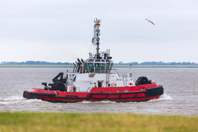 Fishing boat in sea against sky