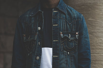 Midsection of person wearing denim jacket