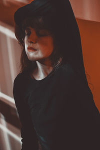 Close-up of woman against wall at home