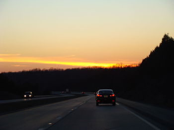 Cars on road at sunset