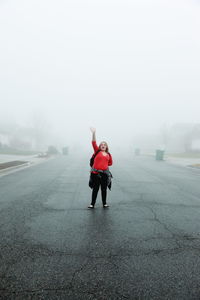 Rear view of woman walking on road