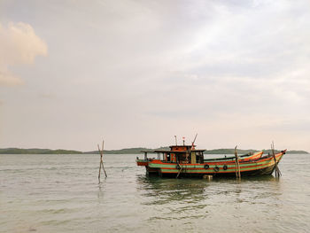 Boat moored in sea against sky