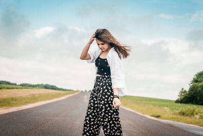 Woman standing on road against sky