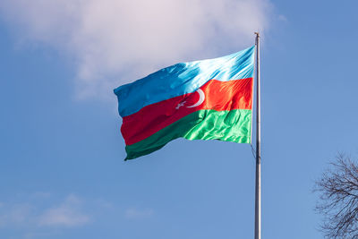 Low angle view of flag against blue sky