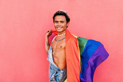 Portrait of young man with rainbow flag