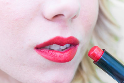 Cropped image of woman applying lipstick