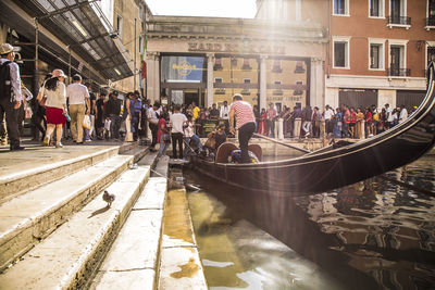 Group of people walking on canal in city