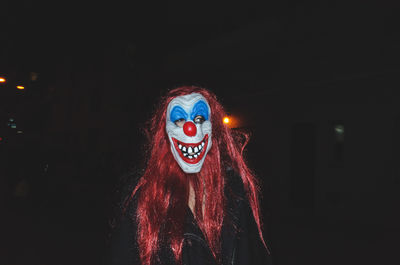 Portrait of woman with red light painting at night