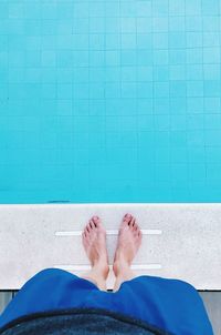 Low section of man standing against swimming pool