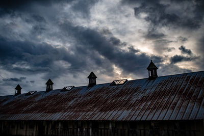 Low angle view of birds perching on roof of building