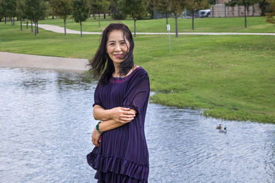 Portrait of a smiling young woman standing in lake