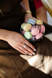 Midsection of woman holding macaroon