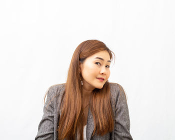 Portrait of beautiful young woman against white background