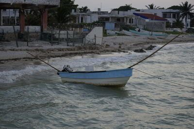 Boat moored on beach against sky