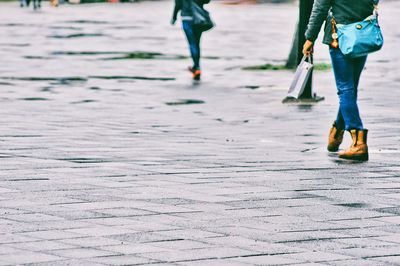 Low section of people walking on stone footpath