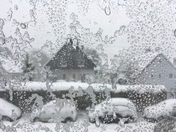 Raindrops on glass window of house during rainy season