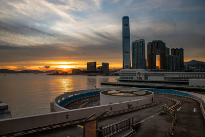 View of river and buildings against sky during sunset