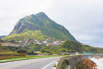 Road by mountain against sky