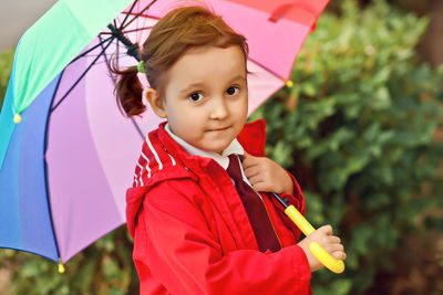 Little child with multicolored rainbow umbrella outdoors