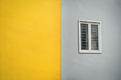 Yellow and gray outdoor wall with window. outside wall duotone color.