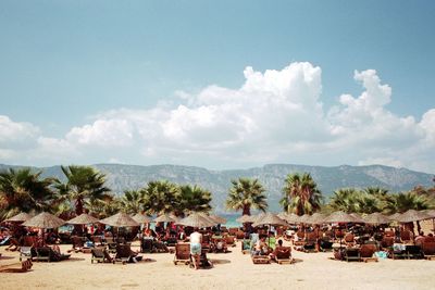 Panoramic view of people on beach against sky