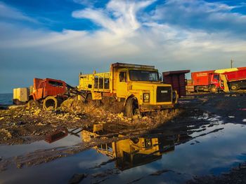 Trucks  against sky with refelection in water