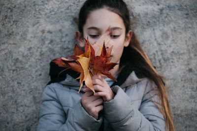 Close-up of girl holding maple leaves