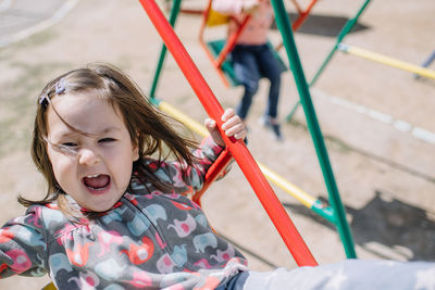 Portrait of girl in swing at playground