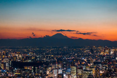 High angle shot of illuminated cityscape against sky at sunset