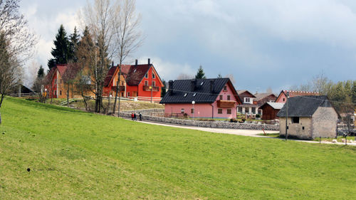 Houses on field against sky