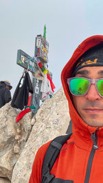 Portrait of young man wearing sunglasses on rock