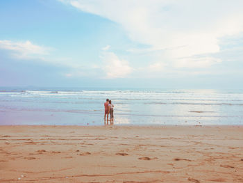 Happy romantic couple enjoying beautiful sunset walk on the beach. pastel colors tone