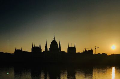 Silhouette of buildings against sky at sunset