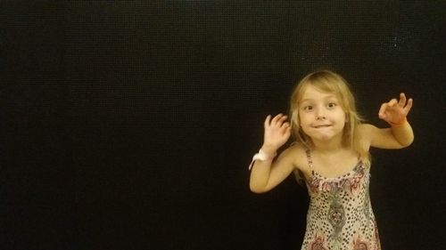 Portrait of a smiling girl over black background