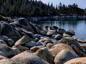 Scenic view of rocky beach against cloudy sky