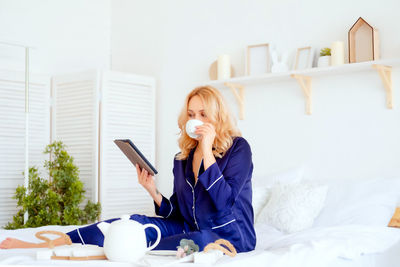 Young woman using mobile phone at home