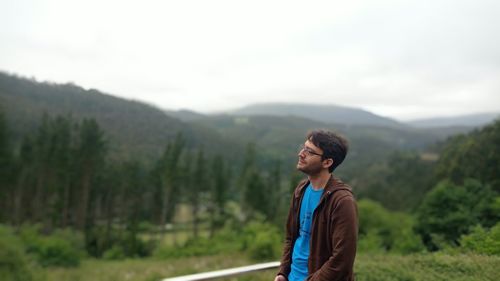 Young man standing on land against sky