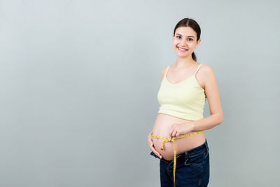 Portrait of a smiling young woman against white background