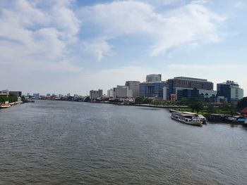 Buildings by sea against sky in city