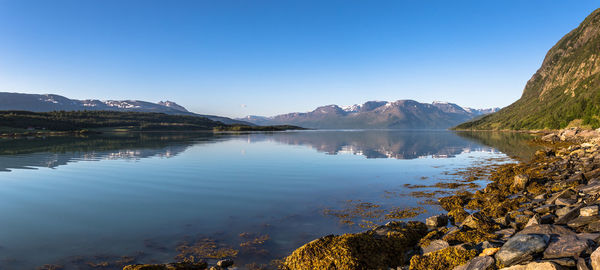 Scenic view of lake against clear blue sky