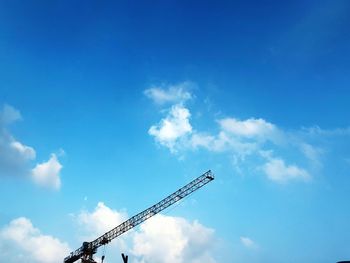 Low angle view of crane against blue sky