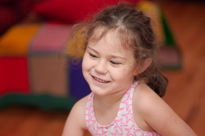 Portrait of a young girl in the livingroom at home making faces and signs of the camera