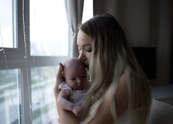 Close-up of young woman looking through window