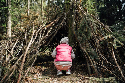 Rear view of woman standing in forest