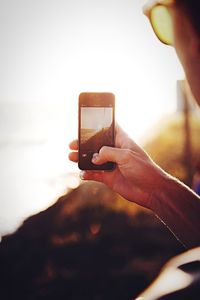 Close-up of cropped hand holding camera